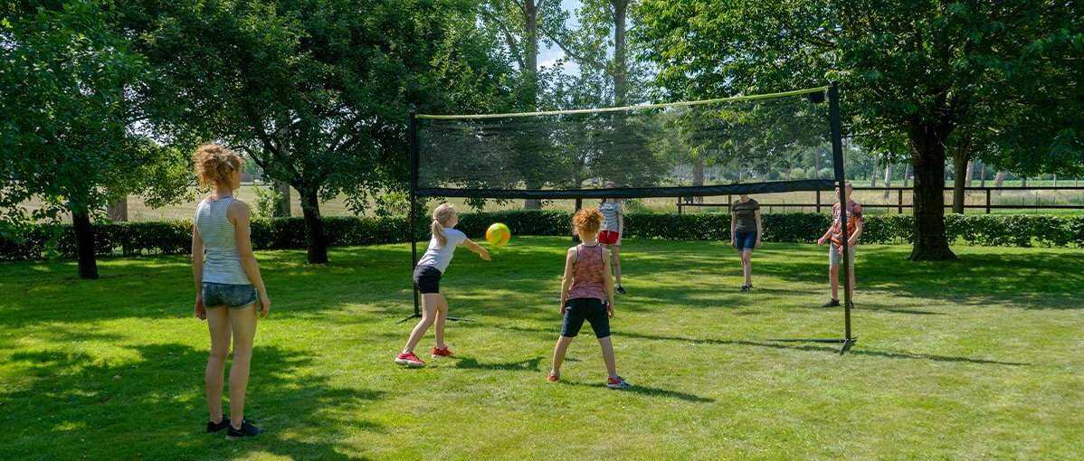 Bild des exit verstellbaren sportnetzes im garten mit spielenden kindern.
